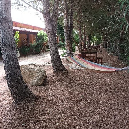 Amaca tavolini e sgabelli sotto gli alberi al fresco