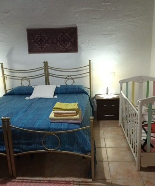 Camera con letto matrimoniale e culla per neonato